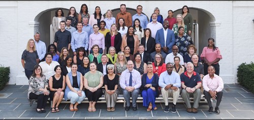 OPM Director Ahuja and Deputy Director Shriver, seated center front row, take a group photo with 55 individuals from the CHCO Council, who attended the Fall Forum, in front of the Federal Executive Institute building.