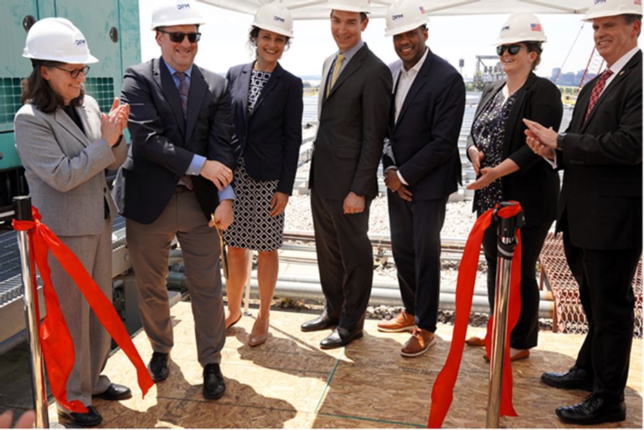 Acting Director Shriver and six individuals stood side by side and worn construction hats at the ribbon-cutting ceremony for the new energy-saving solar panels on the Theodore Roosevelt Building.