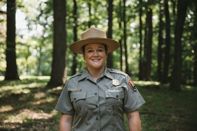 A female park ranger in her uniform standing in a forrest